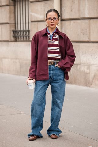 Yoyo Cao wears brown and white Miu Miu polo neck top, blue checked shirt, burgundy Miu Miu jacket, blue jeans, brown loafers, brown belt, outside Miu Miu, during the Womenswear Fall/Winter 2024/2025 as part of Paris Fashion Week on March 05, 2024 in Paris, France.