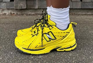 Woman wearing bright yellow New Balance Ganni running sneaker trend.