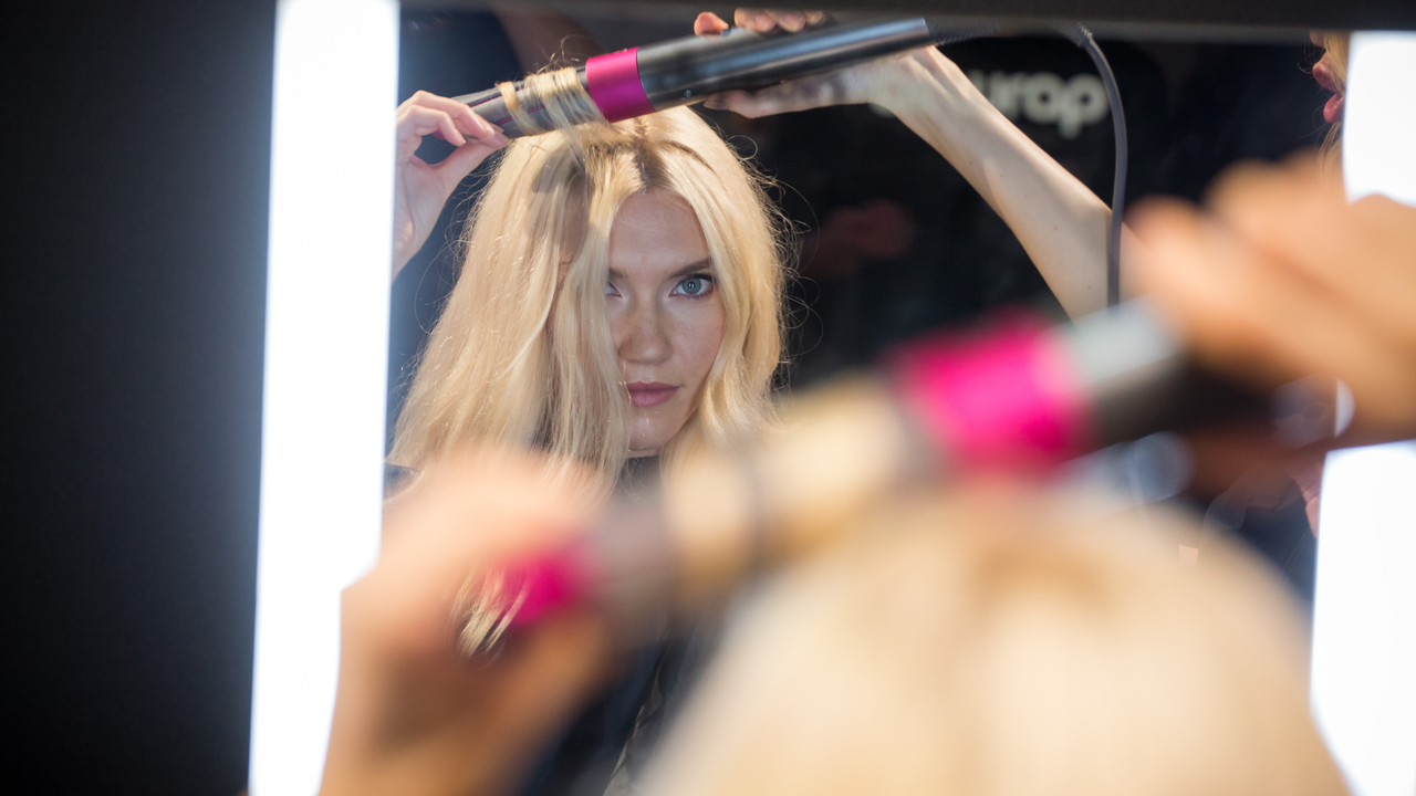 A model demonstrates Dyson Ltd.&#039;s Airwrap product during the company&#039;s beauty technology launch event in New York, U.S., on Tuesday, Oct. 9, 2018. Dyson develops and manufactures vacuum cleaners, hand dryers, fans, and groom tools. 