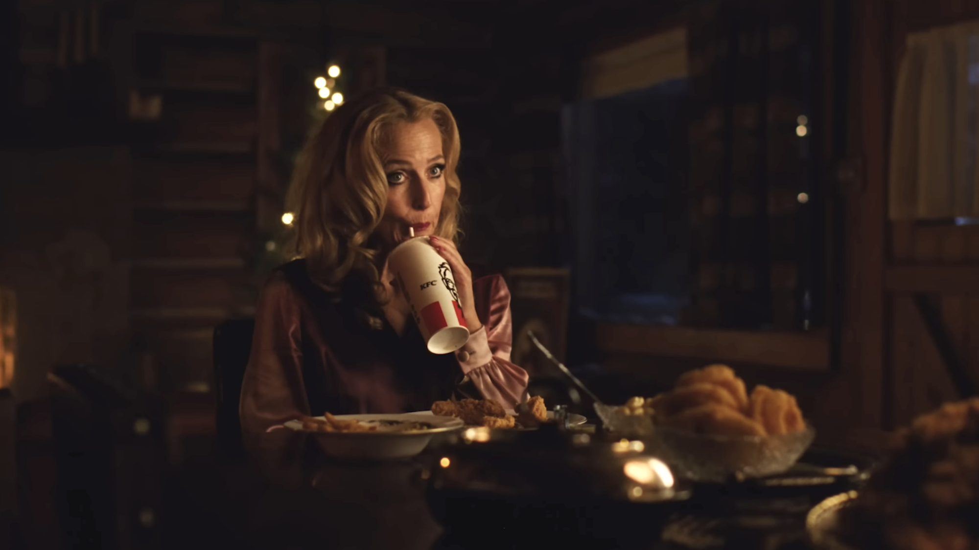 Gillian Anderson sipping a soft drink in a KFC cup in Teenage Sex and Death At Camp Miasma