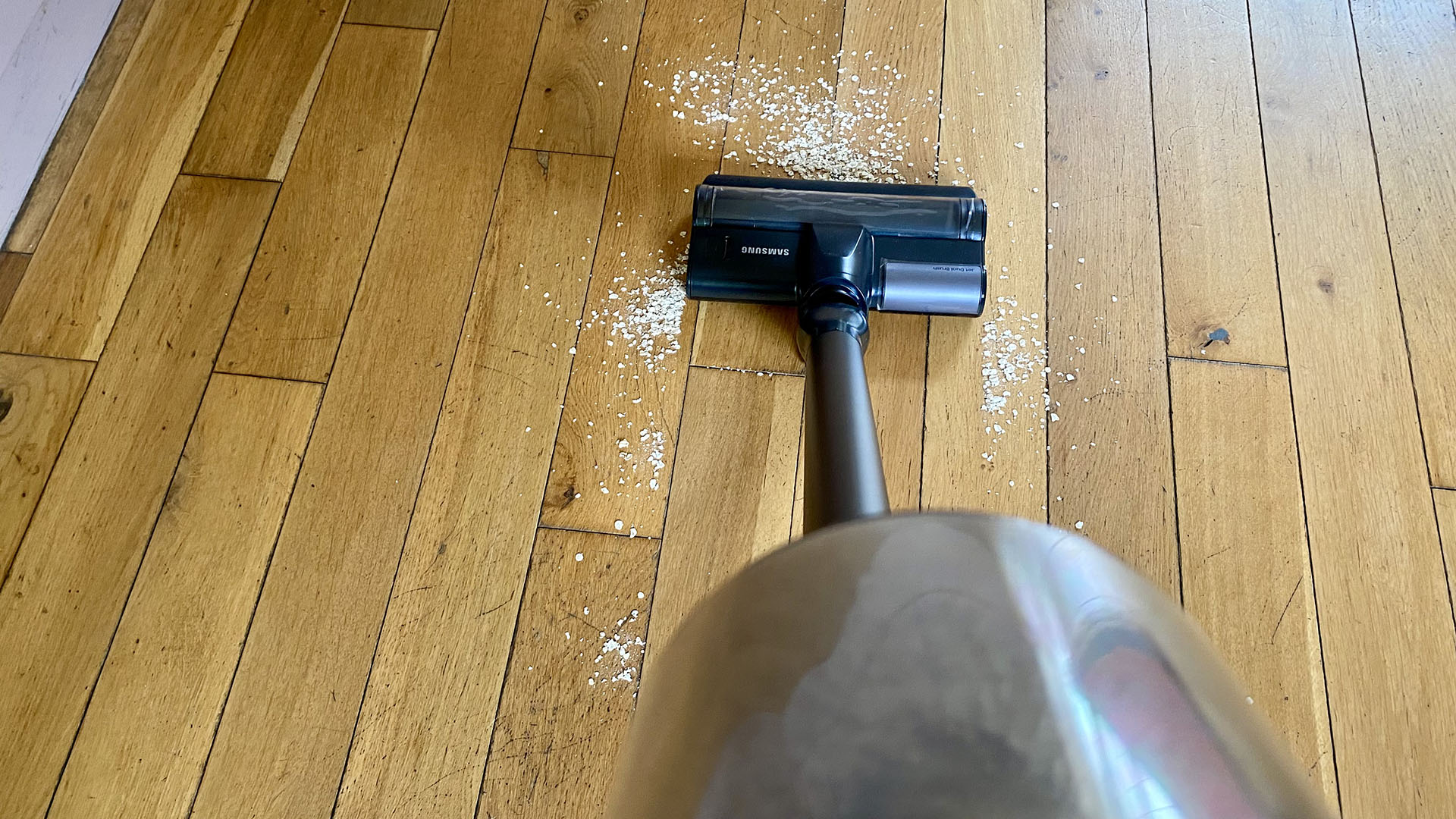 Samsung Jet 85 Pet vacuum cleaner, about to suck up some oats on a hardwood floor
