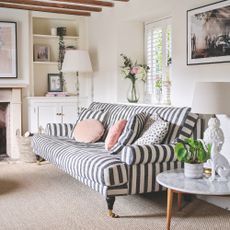 White painted living room with wool carpet and a stripey sofa