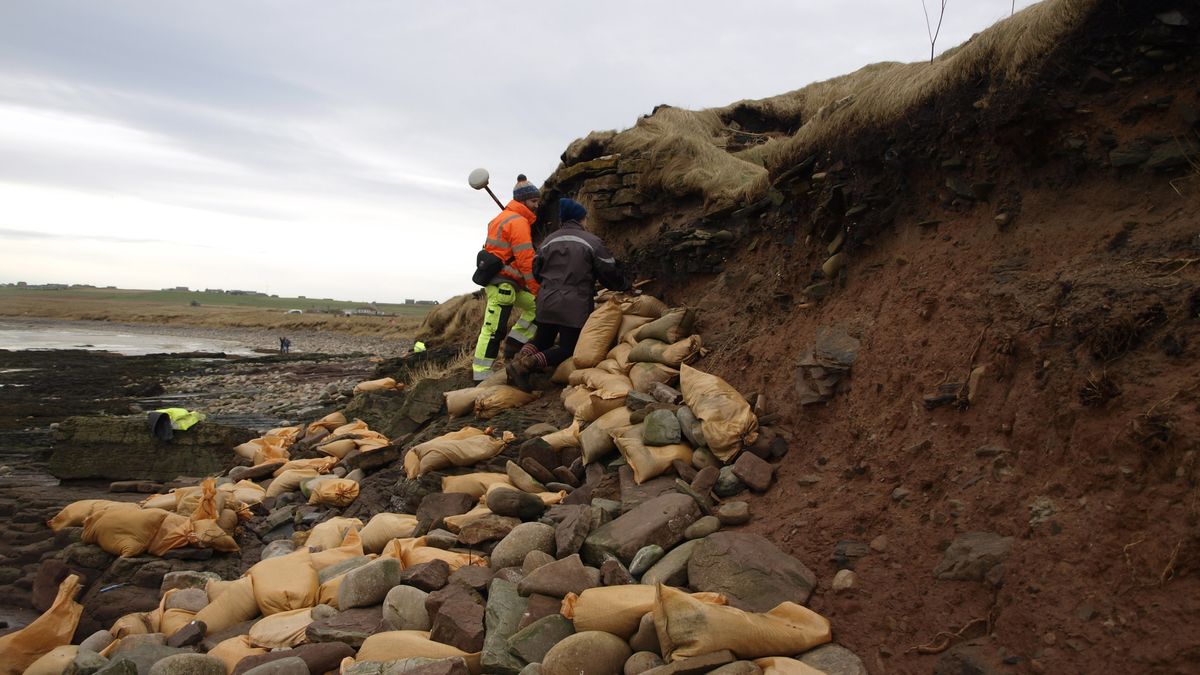 Archaeologists and volunteers are working to preserve human bones exposed by recent storms in an ancient cemetery above a beach on the Orkney Islands.