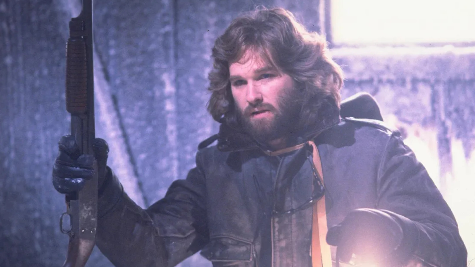 Kurt Russell jako RJ MacReady trzymający strzelbę podczas horroru The Thing.