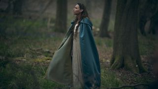 Seanchai, interpretada por Minnie Driver, mira las copas de los árboles del bosque en The Witcher: Blood Origin de Netflix