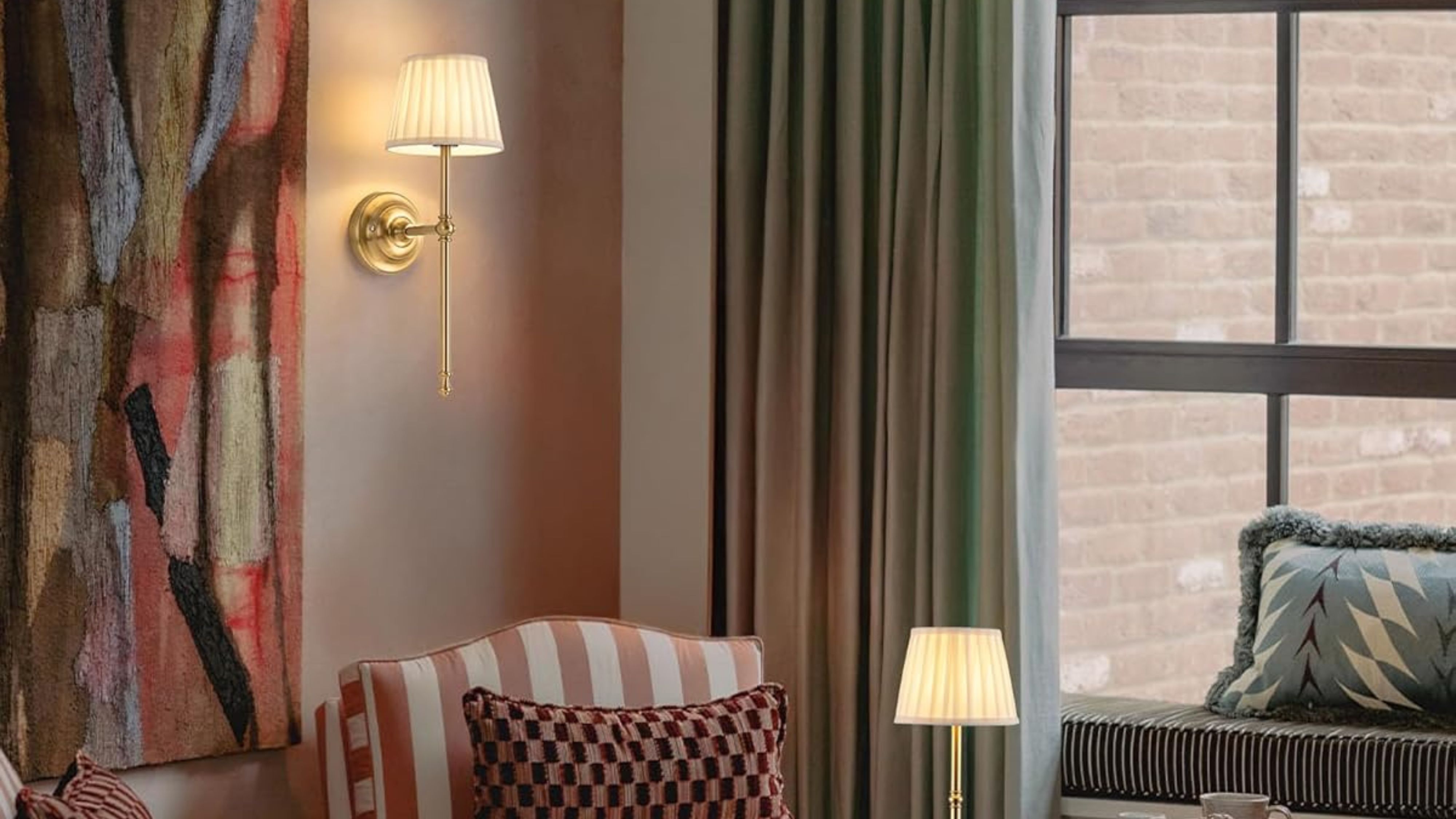 Amazon hotel style cordless wall light with a pleated fabric shade illuminating an art-filled livng room with a striped accent chair