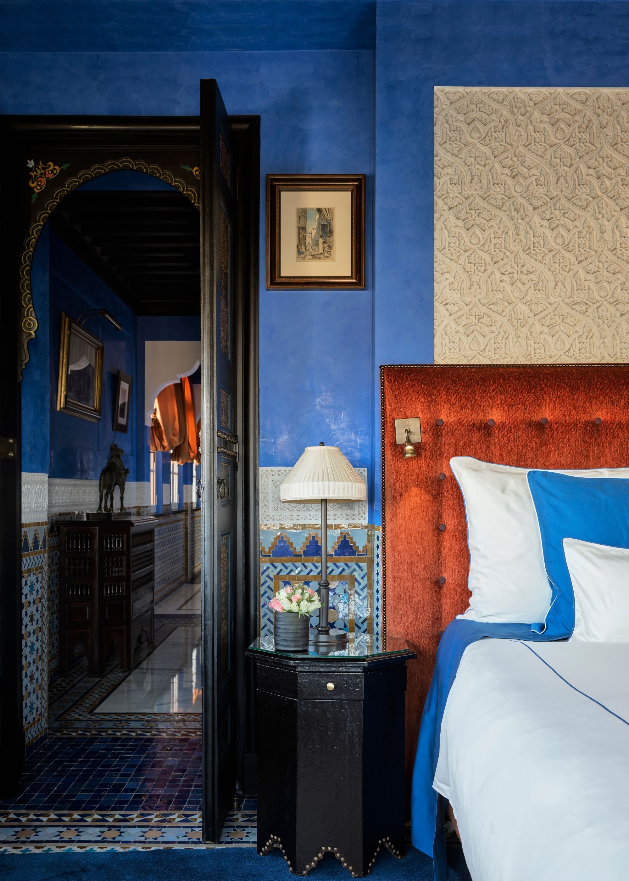 A Moroccan-inspired bedroom with blue walls and zellige tiling