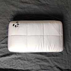 The Panda Hybrid Bamboo Pillow being tested on a grey linen duvet cover