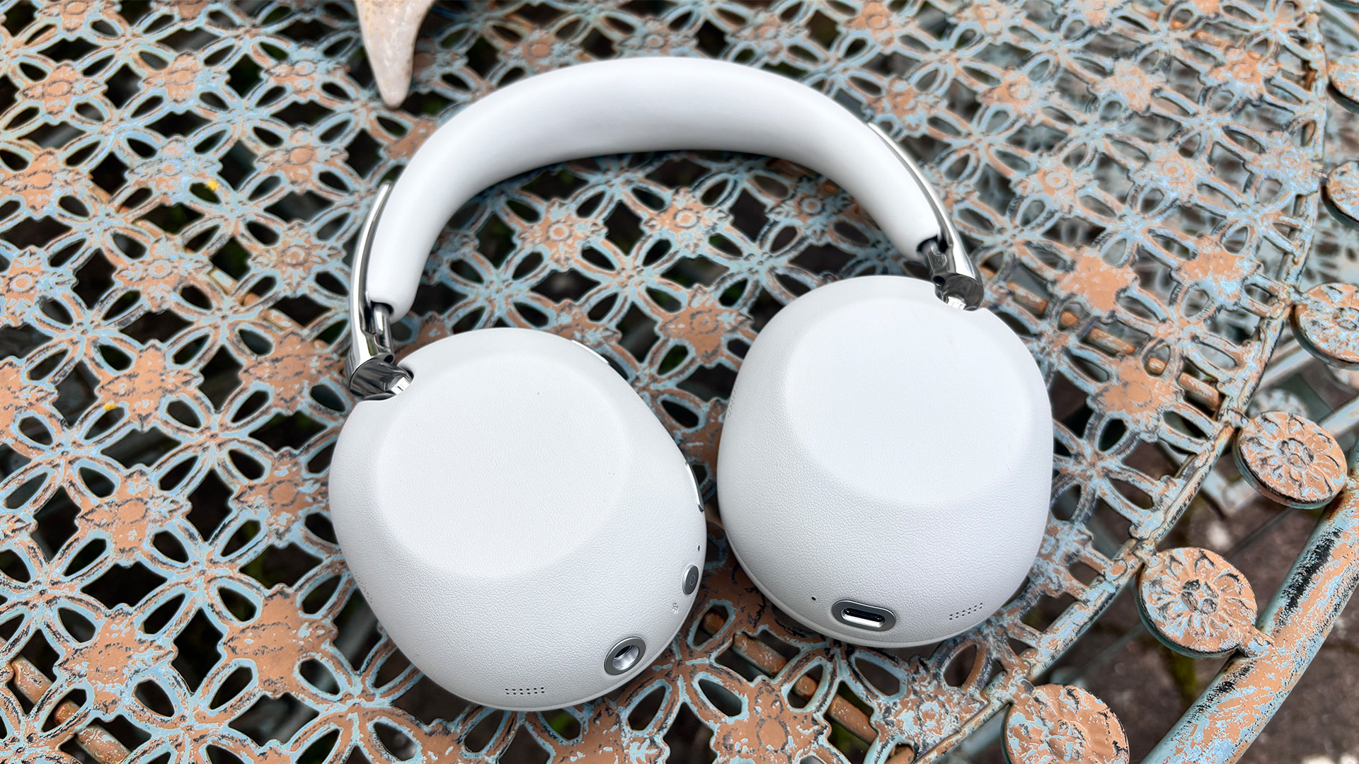 Sony 1000X The Collexion wireless headphones lying earcup-down on metal garden table