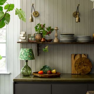 Utility room with green wall panelling and pooky table lamp on counter