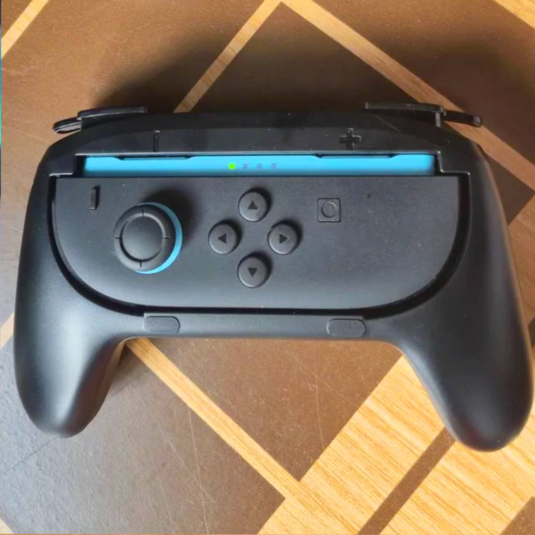 Left Switch 2 Joy-Con attached to grip on wood surface.