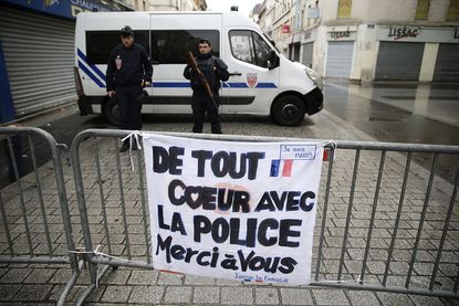 French police guard a blocked-off street in Saint-Denis after anti-terrorism raid