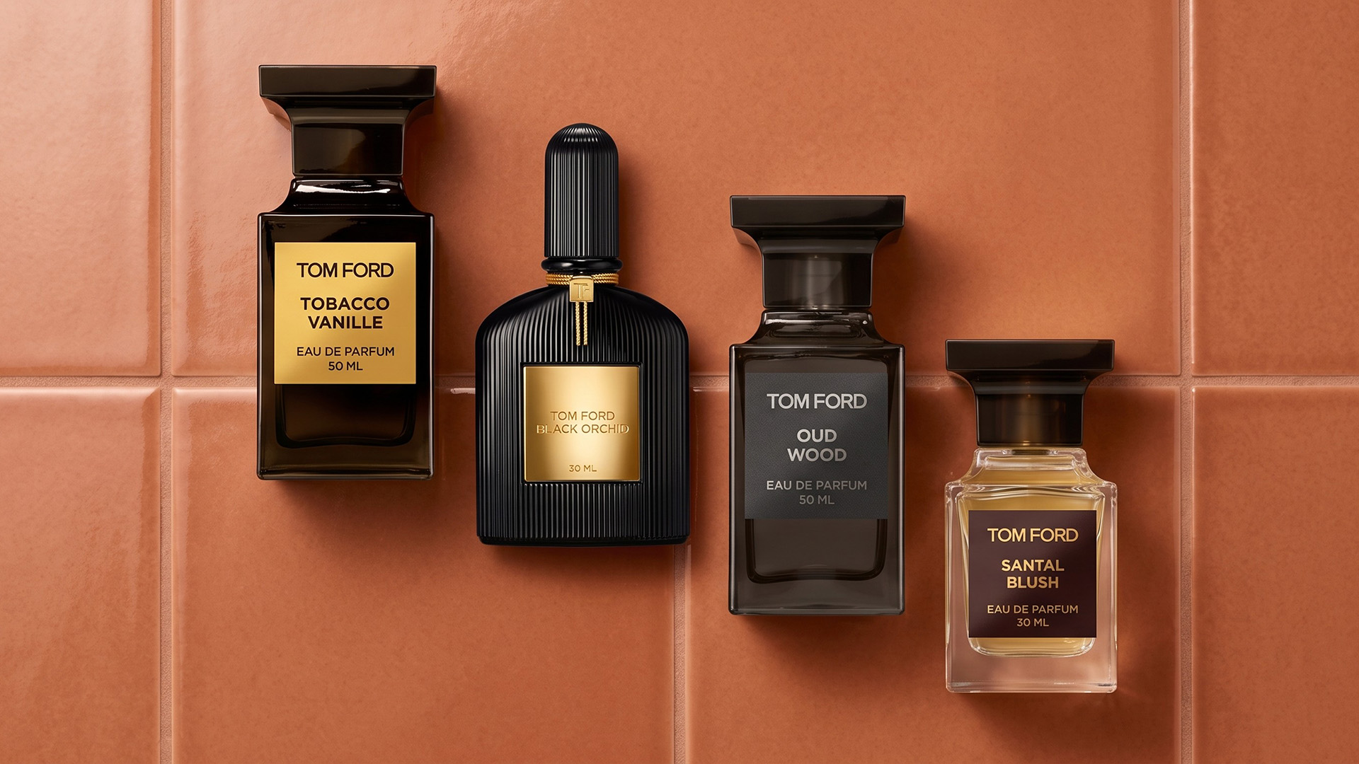 A selection of Tom Ford perfumes on a tiled background.