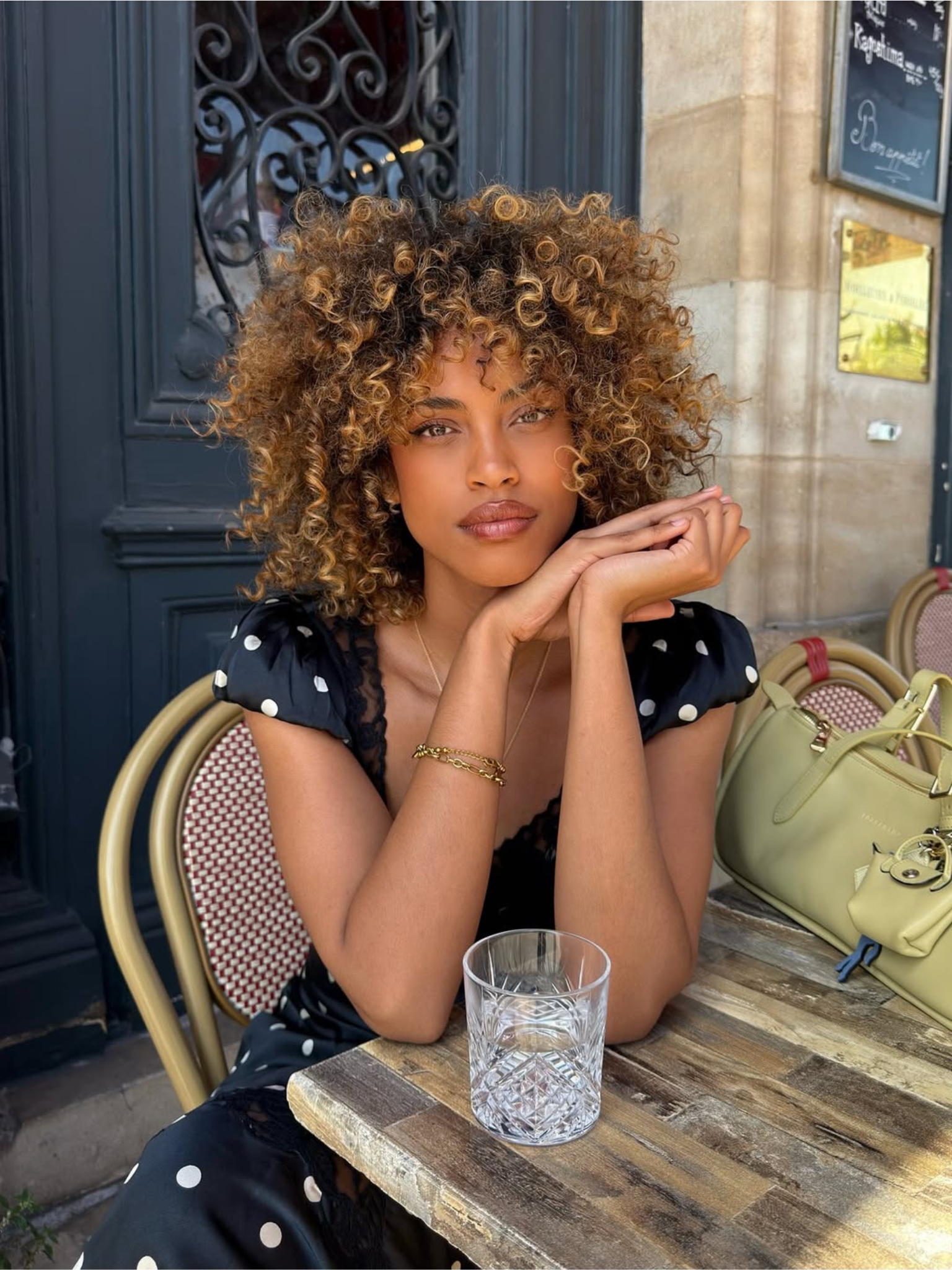 A woman with curly hair sitting outside