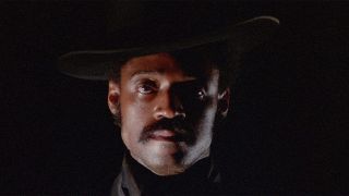 Melvin Van Peebles standing in front of a black background in Sweet Sweetback's Baadasssss Song.