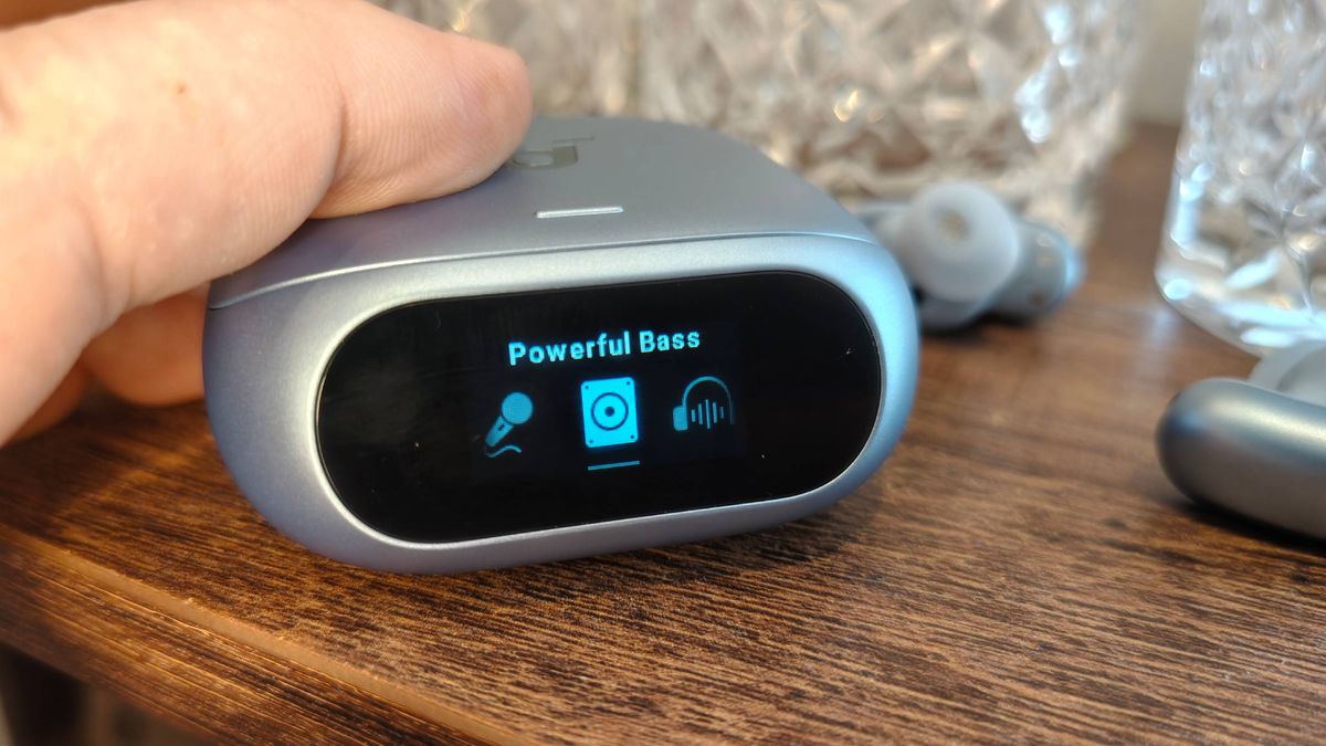 The Anker Soundcore Liberty 5 Pro on a shelf, next to some glasses.