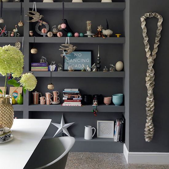 kitchen area with dark grey wall and shelves on wall