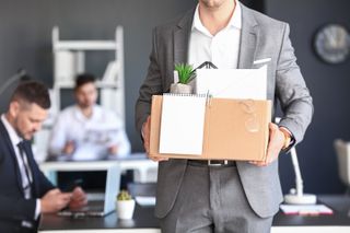 Man leaving a job with box of personal items