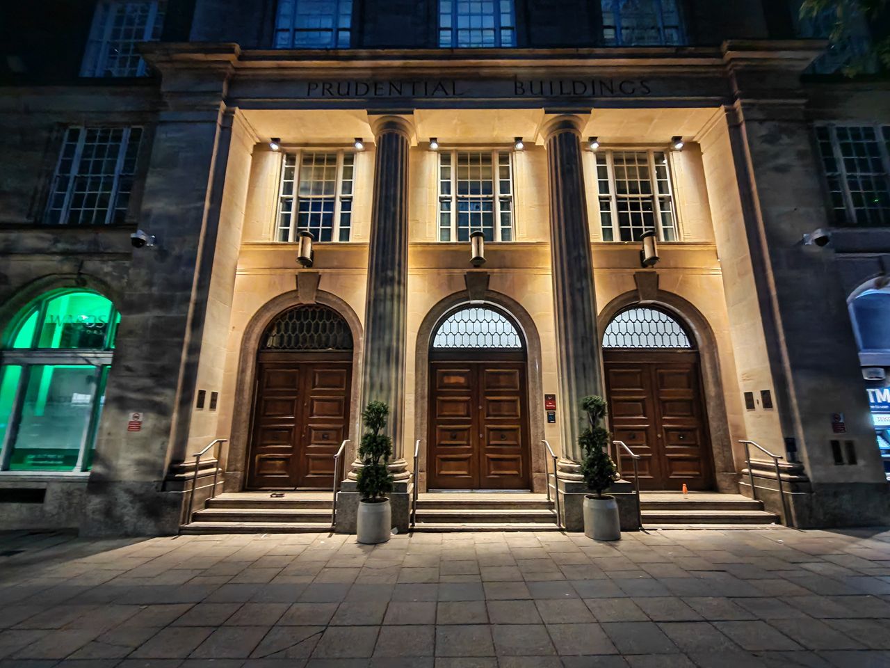 A night shot of the ornate fascia of the Prudential Buildings in Bristol.