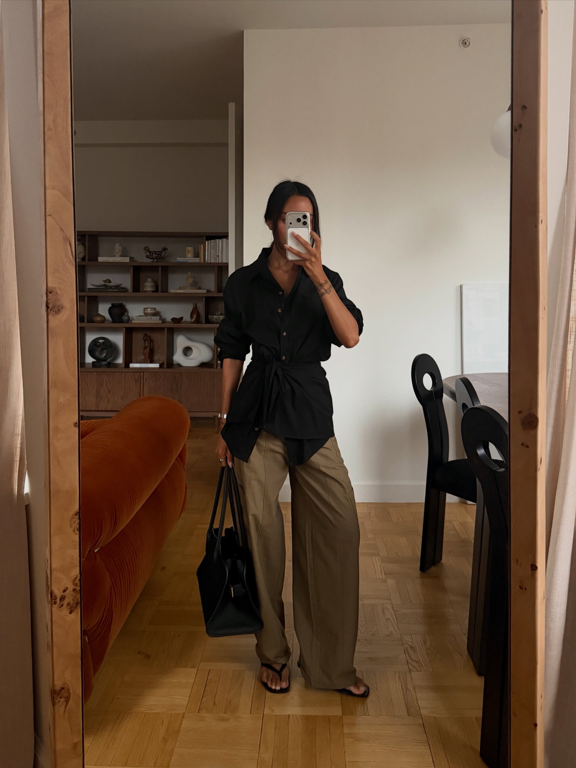 Linh Linner wears a black shirt, khaki trousers