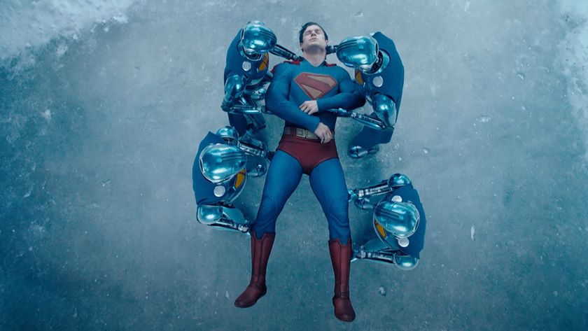 Superman bloodied, being carried by his robot assistants