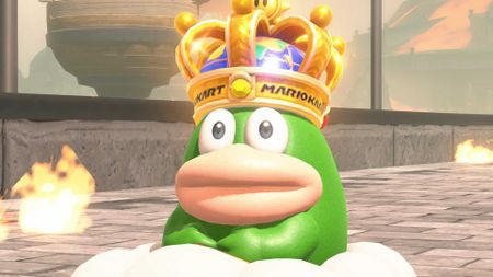 Spike stares at the camera in Mario Kart World, with a crown on his head and surrounded by flames.