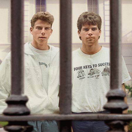 Lyle and Erik Menendez, standing behind a gate evoking jail bars, in the poster for 'The Menendez Brothers' Netflix documentary.