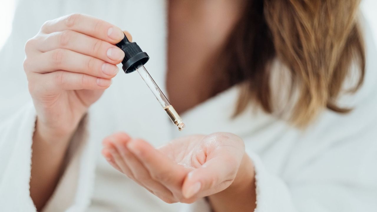 Woman dropping bisabolol serum into her palm 