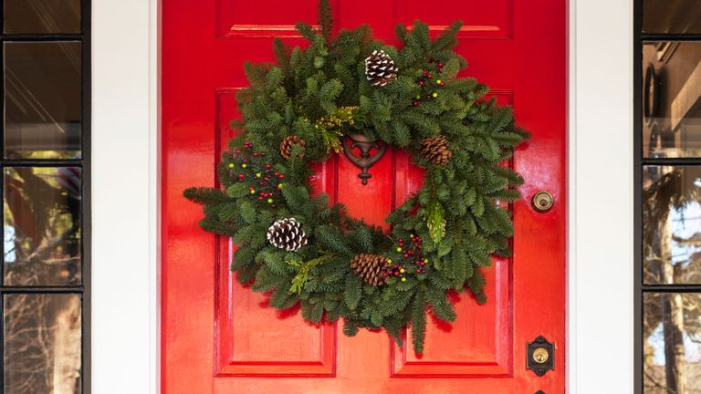 Foliage Christmas wreath hanging on a red front door
