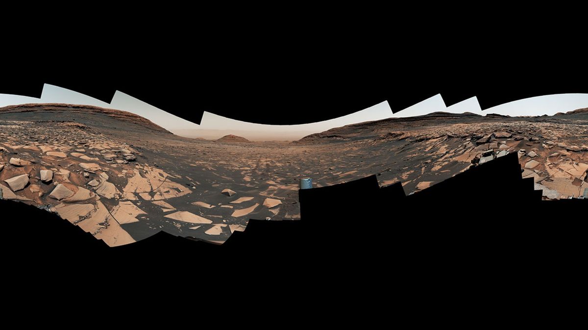 una imagen panorámica que muestra un paisaje polvoriento de color naranja rojizo