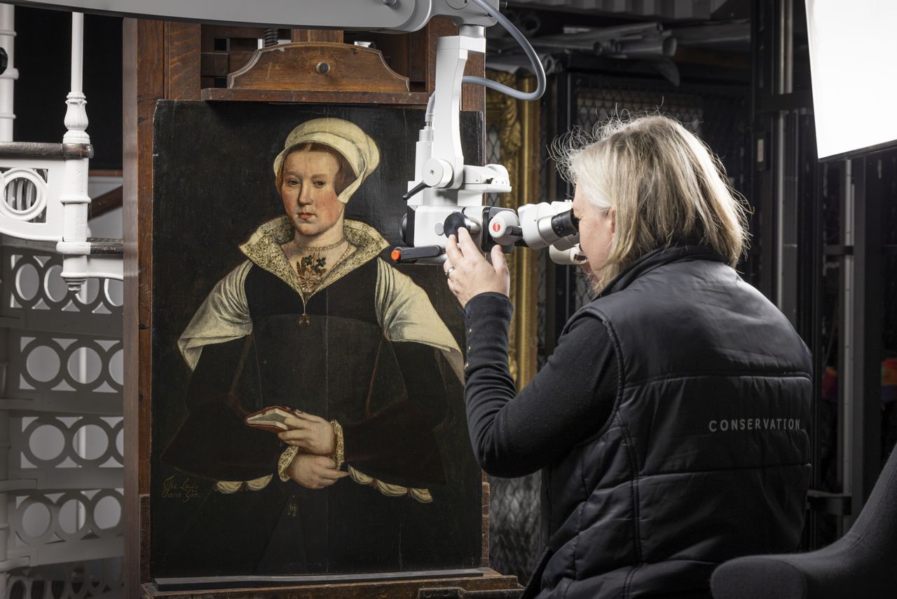 Woman studying an old painting