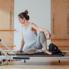 Is Reformer Pilates strength training? A woman on a Reformer machine