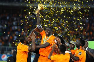Ivory Coast's Yaya Toure (2nd L) holds up the trophy as he celebrates with his teammates after winning the 2015 African Cup of Nations final soccer match between Ivory Coast and Ghana at the Bata Stadium on February 08, 2015 in Bata, Equatorial Guinea.