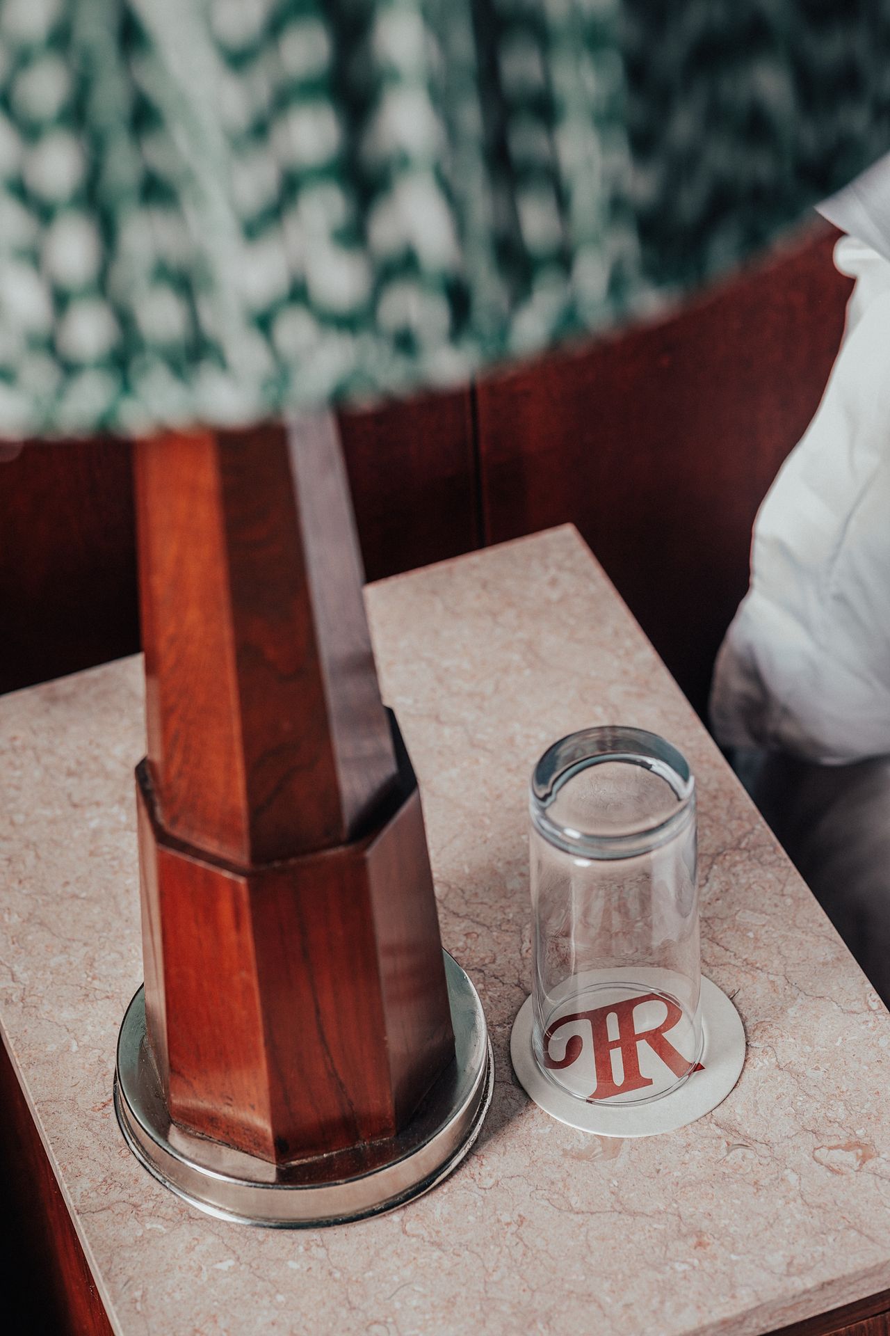 A vibrantly decorated hotel suite inspired by Bombay residences features buttery or tile blue walls adorned with original portraiture artworks, bespoke retro-fueled furnishings in wood, leather, and patterned fabric, and thriving plants.