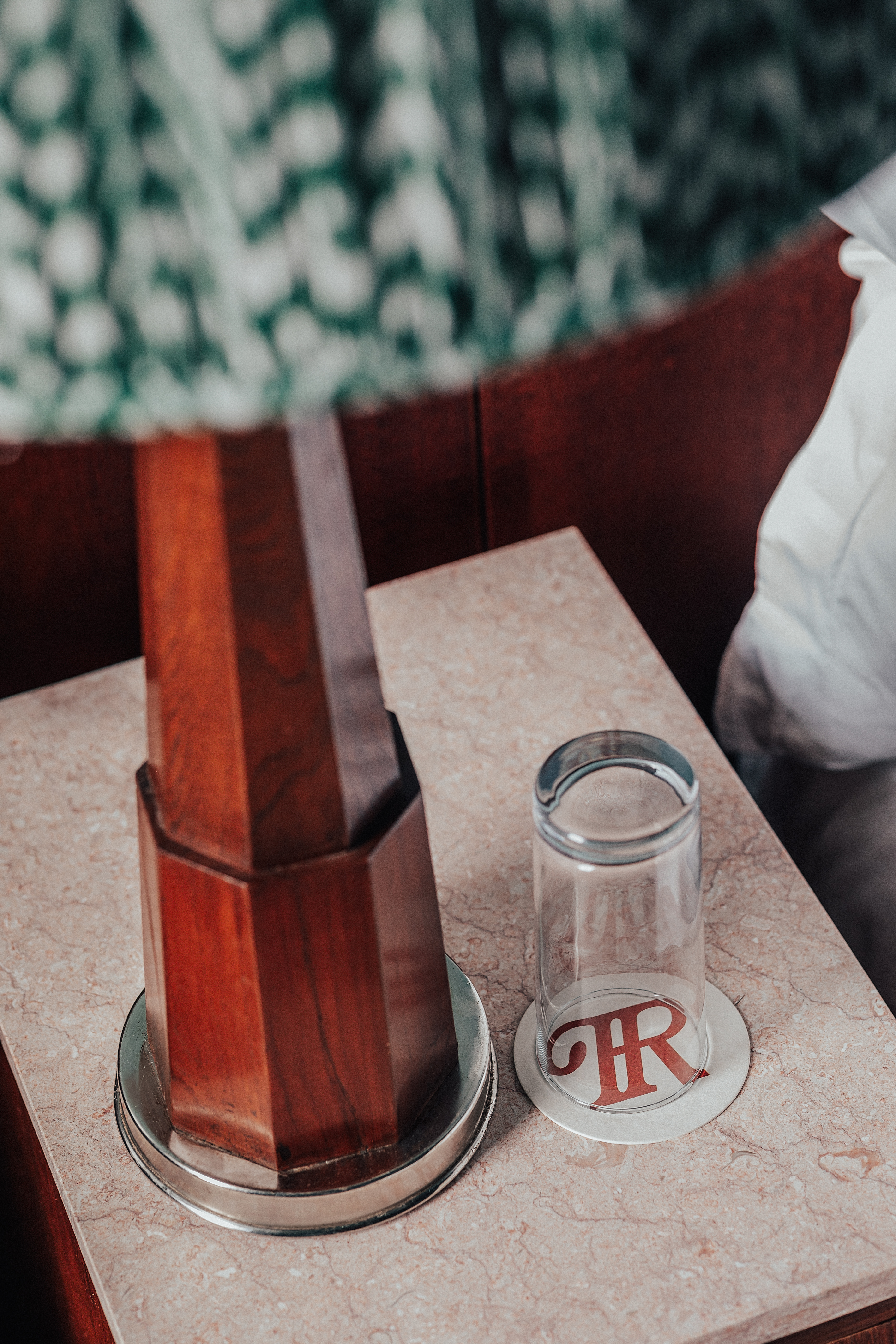 A vibrantly decorated hotel suite inspired by Bombay residences features buttery or tile blue walls adorned with original portraiture artworks, bespoke retro-fueled furnishings in wood, leather, and patterned fabric, and thriving plants.