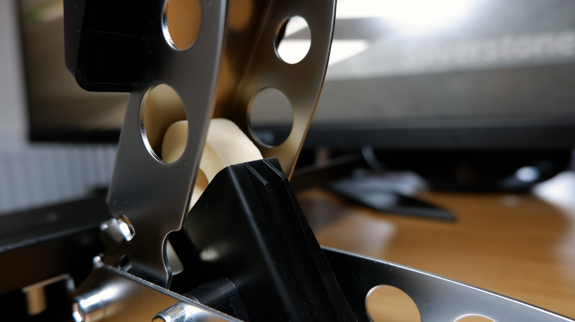 The Fanatec GT DD Pro racing wheel and wheelbase on a desk with monitor playing Assetto Corsa behind.