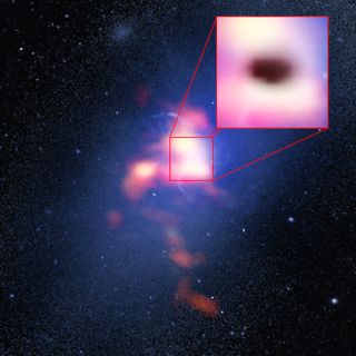 This composite image of Abell 2957 includes a background image taken by the Hubble Space Telescope and a red foreground image from the ALMA radio telescope showing the distribution of carbon monoxide gas in and around the Abell 2597 Brightest Cluster Galaxy. The pull-out box shows the "shadow" of the galaxy's supermassive black hole, which appears to be eating cold clouds of molecular gas.