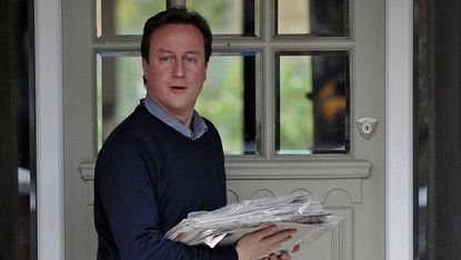 British opposition Conservative party Leader David Cameron returns to his home, after leaving to buy newspapers, in west London on May 09, 2010.Cameron stands on the brink of finally becoming