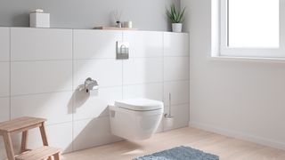 A Grohe rimless wall hung toilet with white tiled backdrop