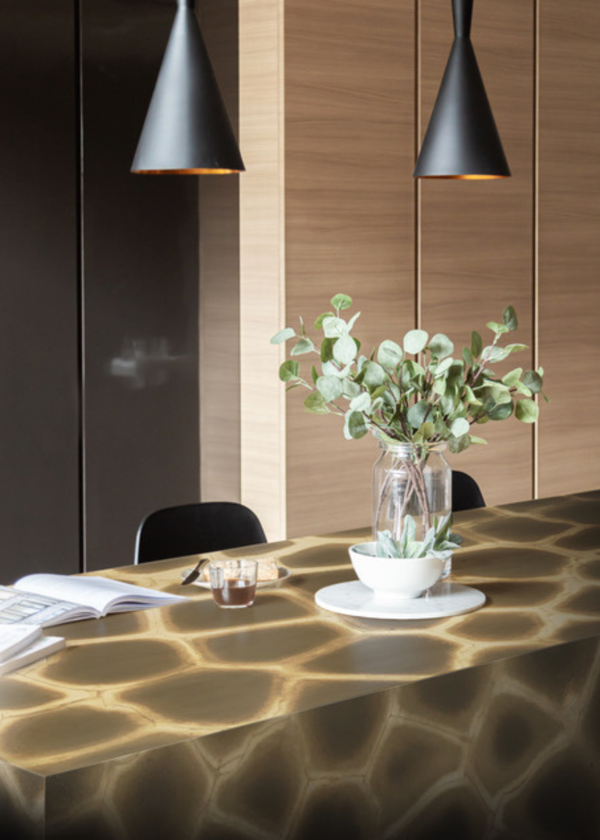 turtle patterned stone kitchen island with pendant lights hanging above and plants in a vase
