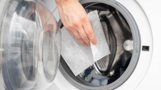 A dryer sheet being added to a clothes dryer