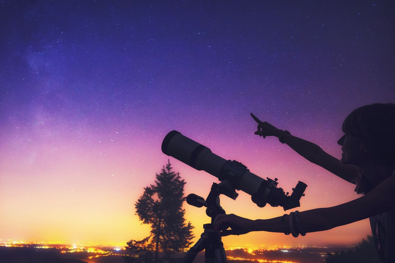 A girl using a telescope.