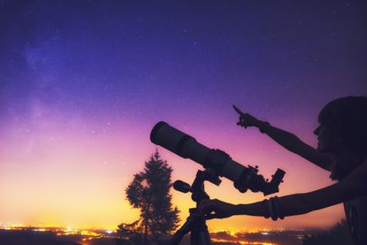 A girl using a telescope.