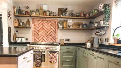 pink and green kitchen with black worktops and open shelving