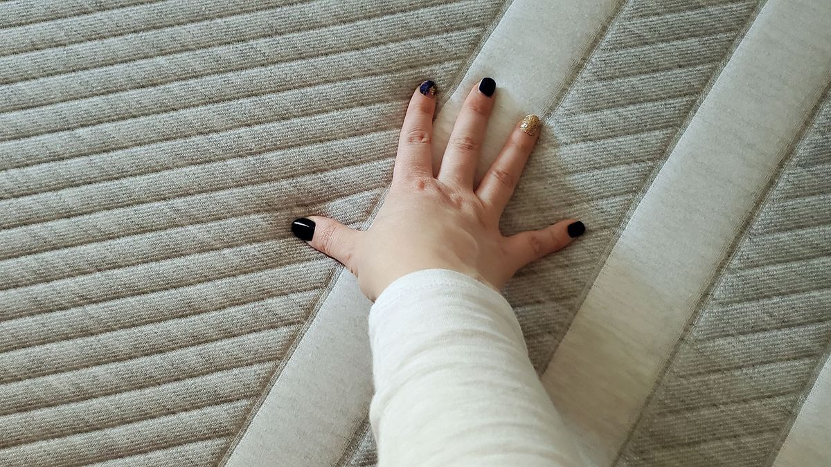 Hand resting on cover of Leesa Original Mattress