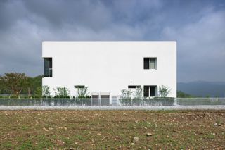 South Korean rounded house's minimalist white side facade