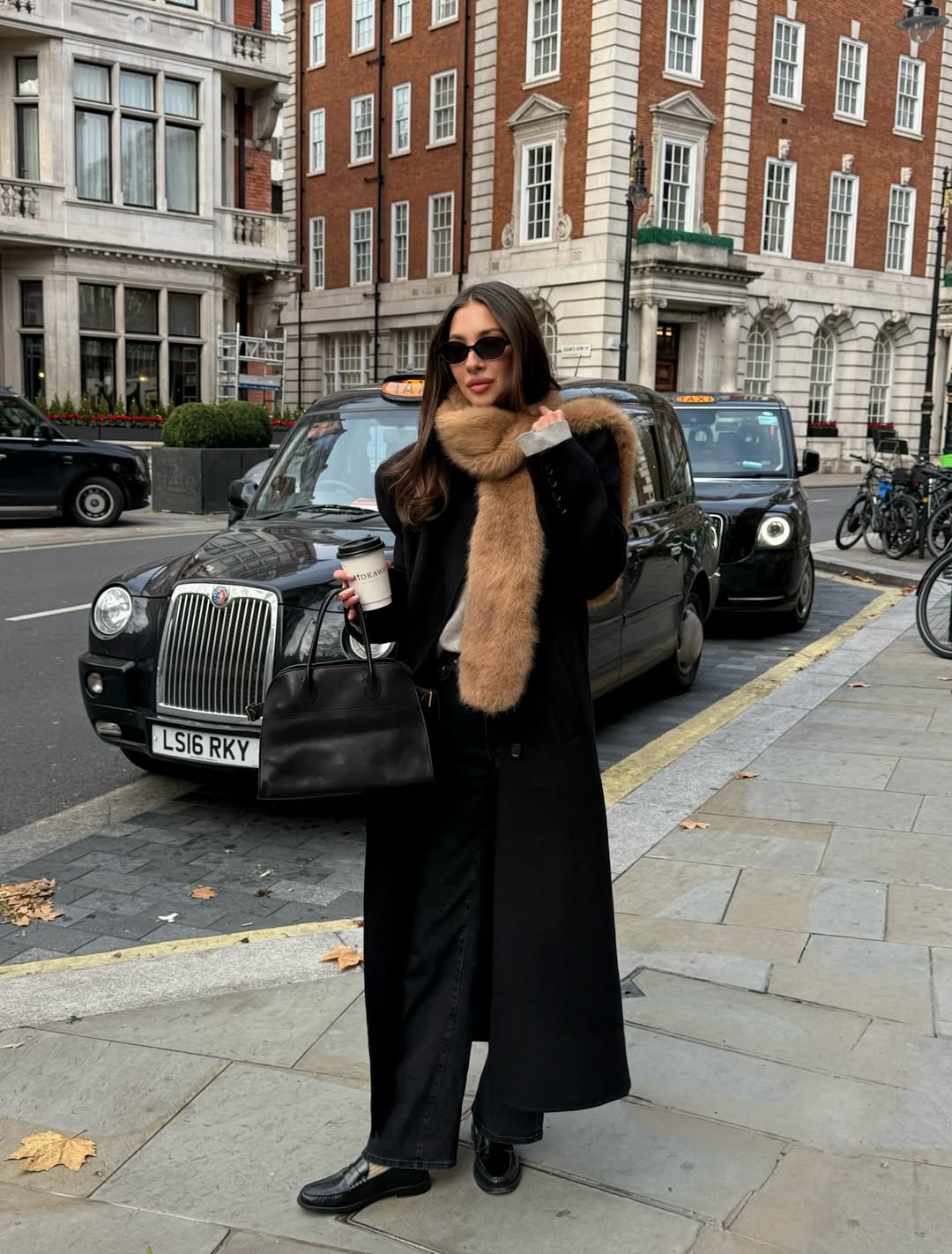Felicia Akerstrom wearing a faux-fur scarf with a black wool coat and black loafers.