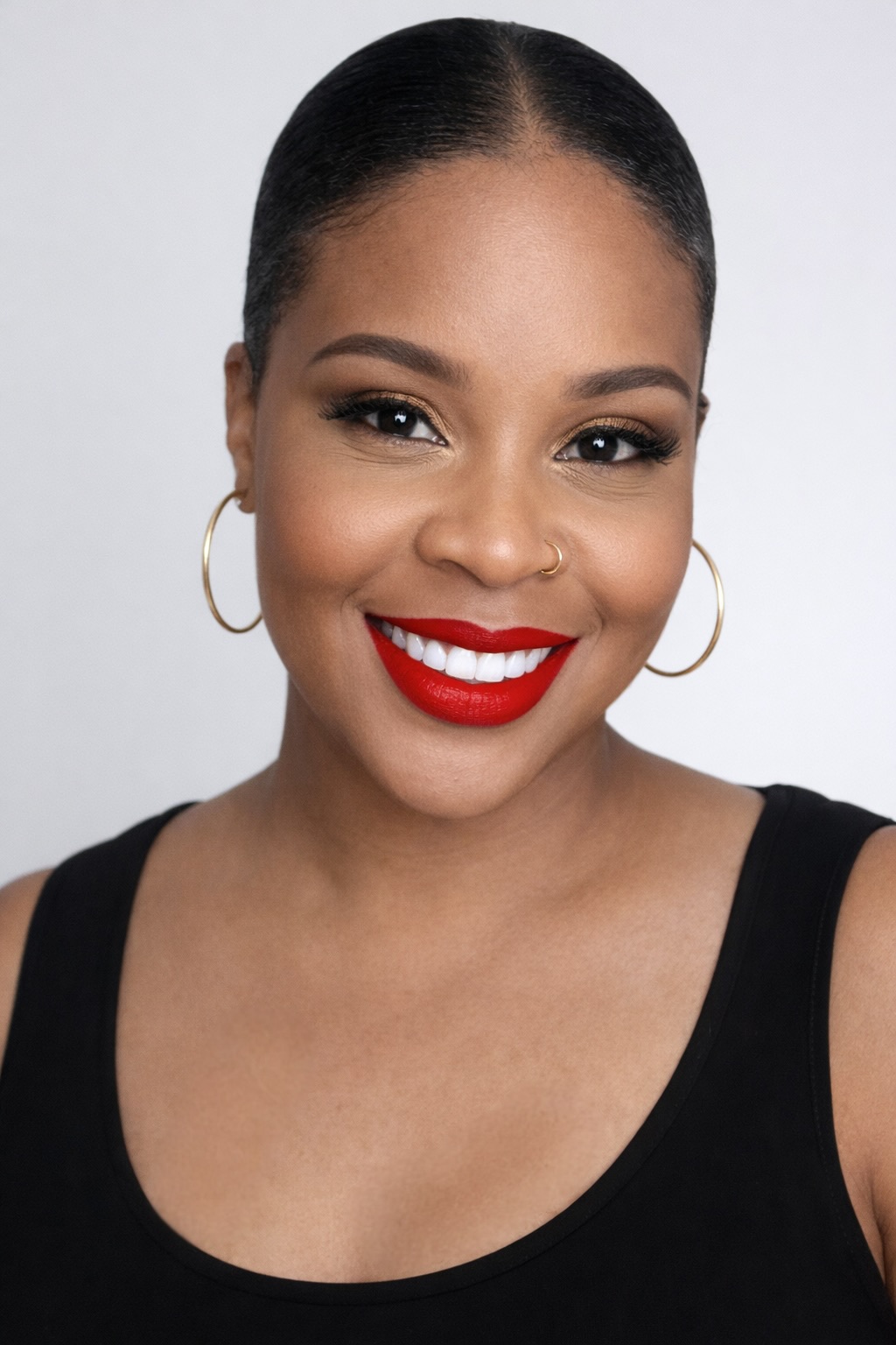 a headshot of a black woman wearing red lipstick on a white background