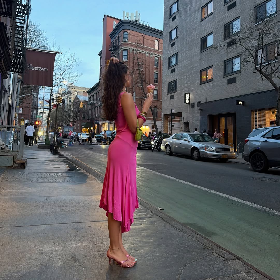 An image of woman wearing metallic shoes, one of the biggest 2026 shoe color trends, with a pink dress.