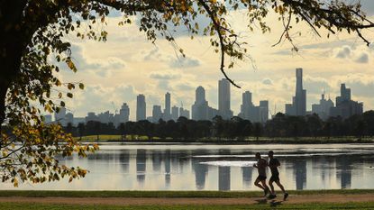 Two people running through an urban park